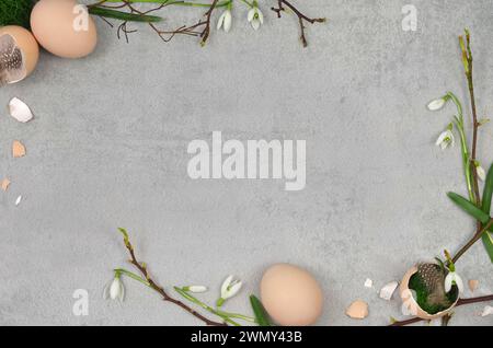 Easter, spring frame made of branches, leaves, egg shells, flowers, feathers with blank space to fill with text. Stock Photo