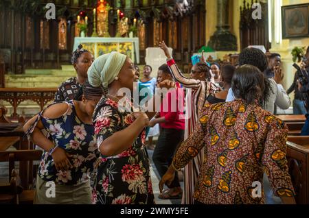 Women worshippers sing, dance and pray on a Sunday inside the Anglican Christ Church Cathedral in Stone Town, Zanzibar, Tanzania Stock Photo