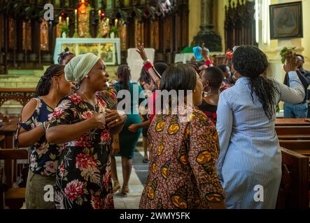 Women worshippers sing, dance and pray on a Sunday inside the Anglican Christ Church Cathedral in Stone Town, Zanzibar, Tanzania Stock Photo