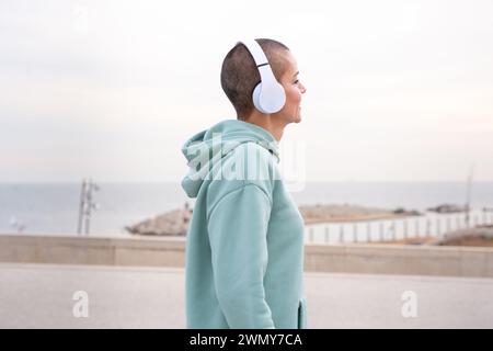 Side view smiling sporty woman with headphones standing outdoors Stock Photo