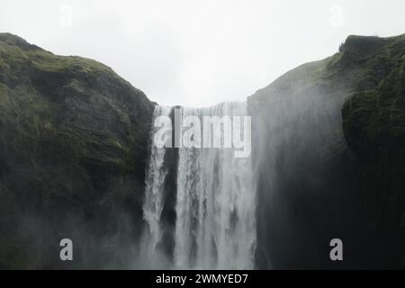 Majestic view of the Skogafoss Waterfall enveloped in mist in the lush landscape of Iceland, a famed natural landmark. Stock Photo