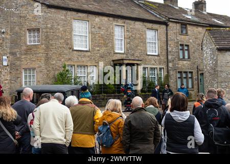 Grassington, Yorkshire, UK. 28th February 2024. Location filming begins for series 5 of the popular Channel 5 and PBS show All Creatures Great & Small. Cast and crew were spotted on the streets of the small Yorkshire Dales town of Grassington, which is converted, twice a  year, in to the fictional town of Darrowby. Pictured - A small crowd watches the filming taking place. Credit: Tom Holmes Photography / Alamy Live News). Stock Photo