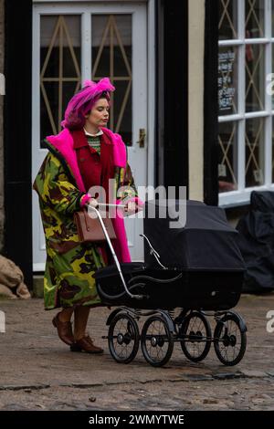 Grassington, Yorkshire, UK. 28th February 2024. Location filming begins for series 5 of the popular Channel 5 and PBS show All Creatures Great & Small. Cast and crew were spotted on the streets of the small Yorkshire Dales town of Grassington, which is converted, twice a  year, in to the fictional town of Darrowby. Pictured - Rachel Shenton (Helen Herriot) films a scene. Credit: Tom Holmes Photography / Alamy Live News). Stock Photo