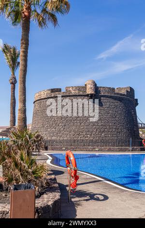 The 18th century defensive tower Castillo de San Buenaventura beside the swimming pool of the Barcelo Fuerteventura Castillo hotel at Caleta de Fuste Stock Photo