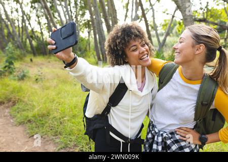 Biracial and Caucasian women take a selfie during a hike on a hike Stock Photo