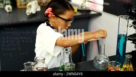 Digital image depicts a student in lab gear with equations, symbolizing a return to education. Stock Photo