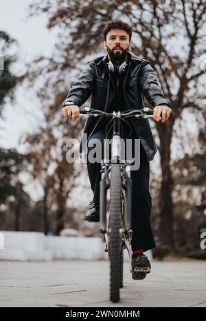 Stylish businessman commuting on a bicycle in an urban setting Stock Photo