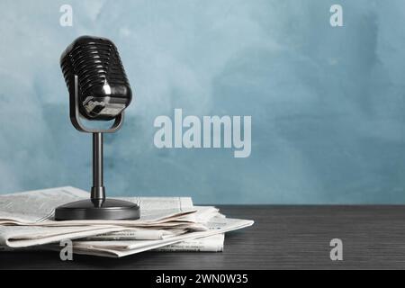 Newspapers and vintage microphone on table, space for text. Journalist's work Stock Photo