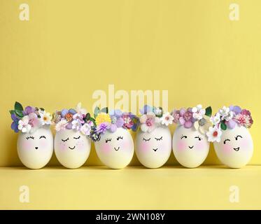 Collection of stylish colors eggs with flowers for Easter celebration on yellow background. Holiday concept. Stock Photo