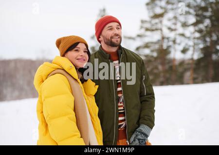 Medium portrait of young Caucasian man and woman in love spending winter day hiking in mountains enjoying view Stock Photo