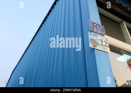 Street address sign at number 22 Zhongshan Road in Xiaoliuqiu, an island off the coast of Taiwan; Flower Vase Coral Rock on building address location. Stock Photo