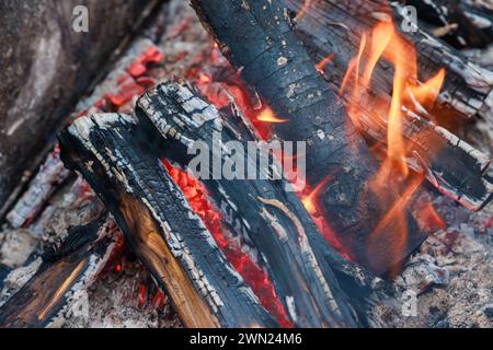 Red and orange flames emanate from bonfire of burning logs. Stock Photo
