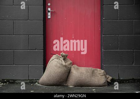 After the storm - sandbags against the door to keep shops dry from the natural disaster weather bomb that was Cyclone Gabrielle in 2023. Stock Photo