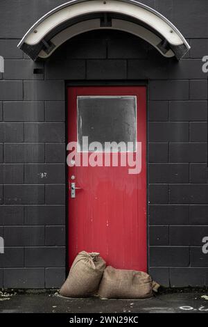 After the storm - sandbags against the door to keep shops dry from the natural disaster weather bomb that was Cyclone Gabrielle in 2023. Stock Photo