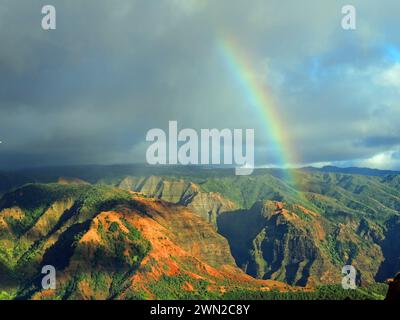 rainbow over colorful  waimea canyon on a stormy day   in kauai, hawaii Stock Photo