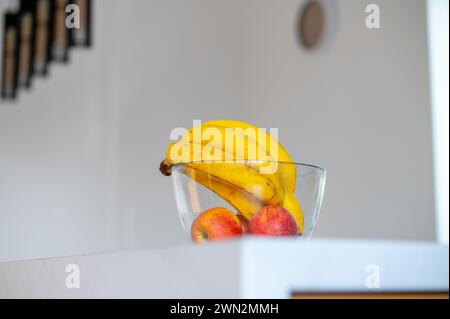 Bright daylight highlights a banana in a glass bowl on the kitchen counter Stock Photo