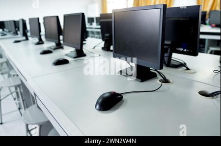 Row of computers neatly placed in computer lab Stock Photo