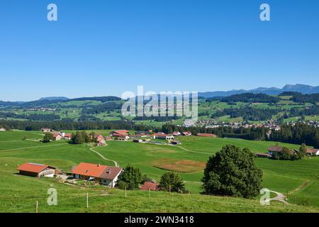 Alpine Foothills Charm: Rural Mountainside Living with Farmer's Homesteads. Mountain Countryside: Farmer's Dwellings, Pastures, and the Sky Above Stock Photo