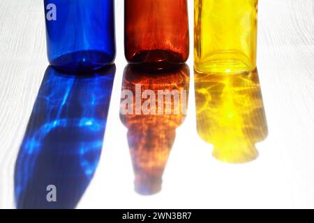 Set of empty multicolored glass bottles with nice shadow against sun light Stock Photo