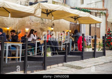 Matera, Italy–Dec 30, 2023: Tourists enjoy vacation at a restaurant terrace Stock Photo