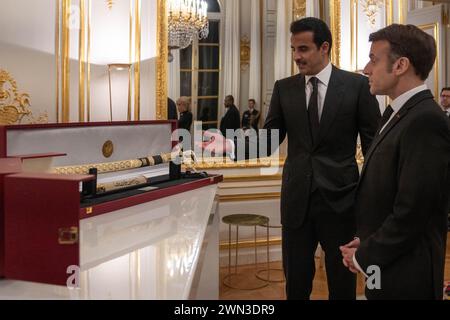 Paris, France. 27th Feb, 2024. Emir of Qatar Sheikh Tamim bin Hamad Al Thani (2nd from R) presents a gift to French president Emmanuel Macron, at the Elysee Palace, in Paris, France, on February 27, 2024, on the first day of the Emir's State Visit to France. Photo by Balkis Press/ABACAPRESS.COM Credit: Abaca Press/Alamy Live News Stock Photo