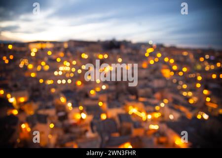 blurry Arial view of Matera sassi at sunset with street light on, Italy Stock Photo