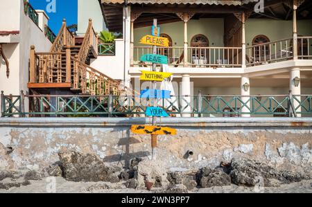 A sign reading 'please leave nothing but your footprints' on the beach in Stone Town, Zanzibar, Tanzania Stock Photo