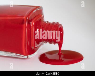 A close-up of a red nail polish spilled on a white surface Stock Photo
