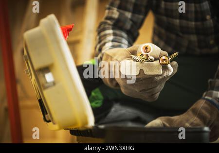 Construction Contractor Worker with Bunch of Metal Screws in His Hand Stock Photo