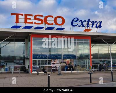 St Helens, UK - Jan 4 2024: Corporate signage and the customer entrance at a Tesco Extra superstore in St Helens, Merseyside, England, UK. Stock Photo