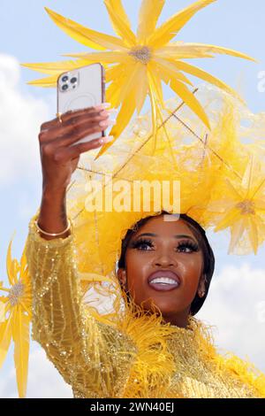 22.06.2023, Ascot, Windsor, GBR - Elegant gekleidete Frau mit Hut macht von sich beim Pferderennen Royal Ascot ein Selfie. 30-40 Jahre, Ascot, aussen, Aussenaufnahme, Besucherin, britisch, chiq, elegant, Eleganz, Emotion, England, englisch, Europa, europaeisch, farbig, Farbige, Frau, Freizeit, Galopprennen, Galopprennsport, Galoppsport, Gesellschaft, Grossbritannien, Handy, HF, High Society, Hochformat, Hut, Kleidung, Kopfbedeckung, Mensch, Mobiltelefon, Mode, modisch, Person, Pferderennen, Pferderennsport, Pferdesport, Portraet, Portrait, Royal Ascot, schick, schwarz, Schwarze, Selfie, Smartp Stock Photo