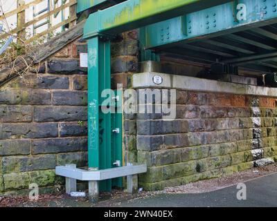 St Helens, UK - Jan 4 2024: A steel framework painted green provides impact protection to a sandstone railway bridge in St Helens, Merseyside Stock Photo