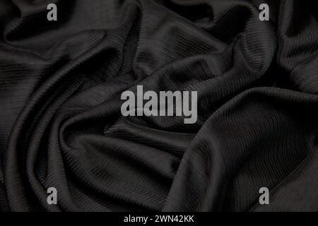 Close-up of black textured fabric swatch on dark background Stock Photo