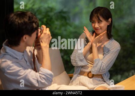 Young couple taking photos in café Stock Photo