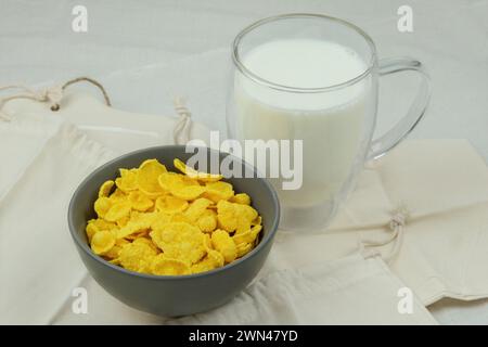 Breakfast cereals. Cornflakes in bowls and cup of milk on a light background. Fast food. Stock Photo