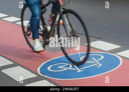Blurred bicycle on a cycle path with a blue cycle path symbol Stock Photo