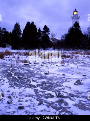 Cana Island Light shines over the Lake Michigan shore in pre-dawn light, Door County, Wisconsin Stock Photo