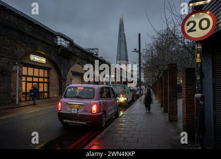 Southwark, London, UK: Druid Street alongside the London Bridge to Greenwich Railway Viaduct with view of the Shard skyscraper Stock Photo