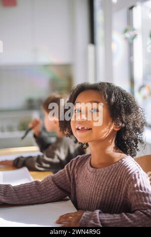 Girl sitting in the classroom and looking up with smile Stock Photo - Alamy