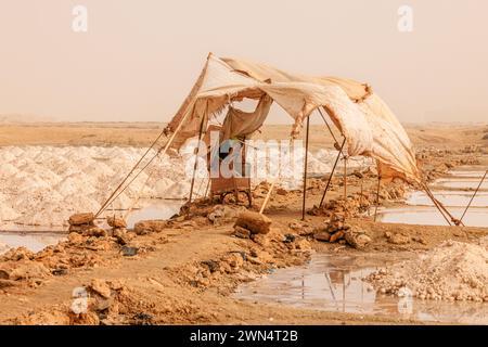 a tattered canvas shelter overlooks the santa maria salt pans and numerous mounds of salt Stock Photo