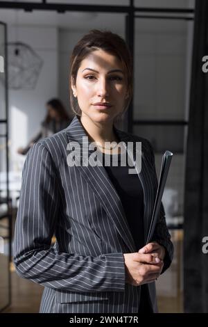 Portrait of confident saleswoman holding folder at home Stock Photo