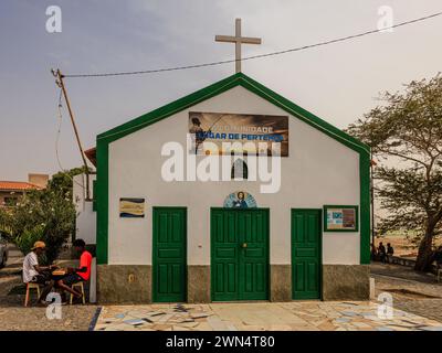 two men sit playing the board game mancala outside the capela de sao jose in palmeira port sal island cape verde Stock Photo