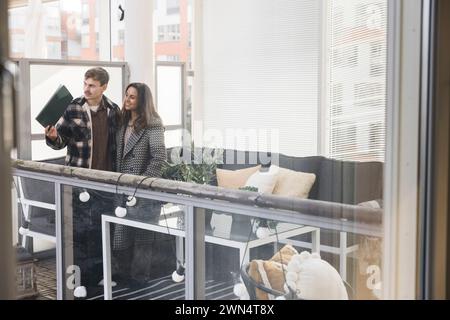 Multiracial couple looking through window while exploring new house Stock Photo