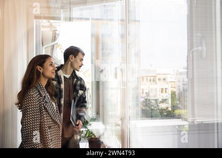 Couple exploring new house while standing in balcony Stock Photo