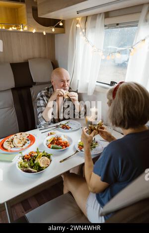 Retired senior couple eating lunch together in motor home Stock Photo