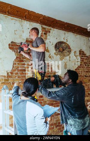 Female construction manager assisting workers in working at site Stock Photo