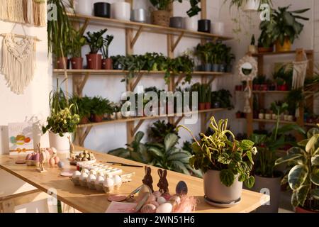 Selective focus wide shot of eggs and decorations for easter on table in modern plant shop interior Stock Photo