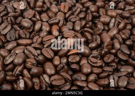 Coffee bean background. Roasted coffee beans on the entire surface. Brown coffee. Flat layout with top view. Stock Photo