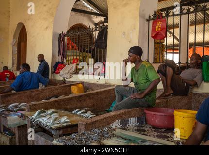 Men sell fish  inside Stone Town Market, Zanzibar, Tanzania Stock Photo
