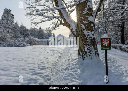 Marienbad, Czech Republic - December 4 2023: Yellow and white building of Ferdinand Spring pavilion during winter time and trees in the park covered w Stock Photo